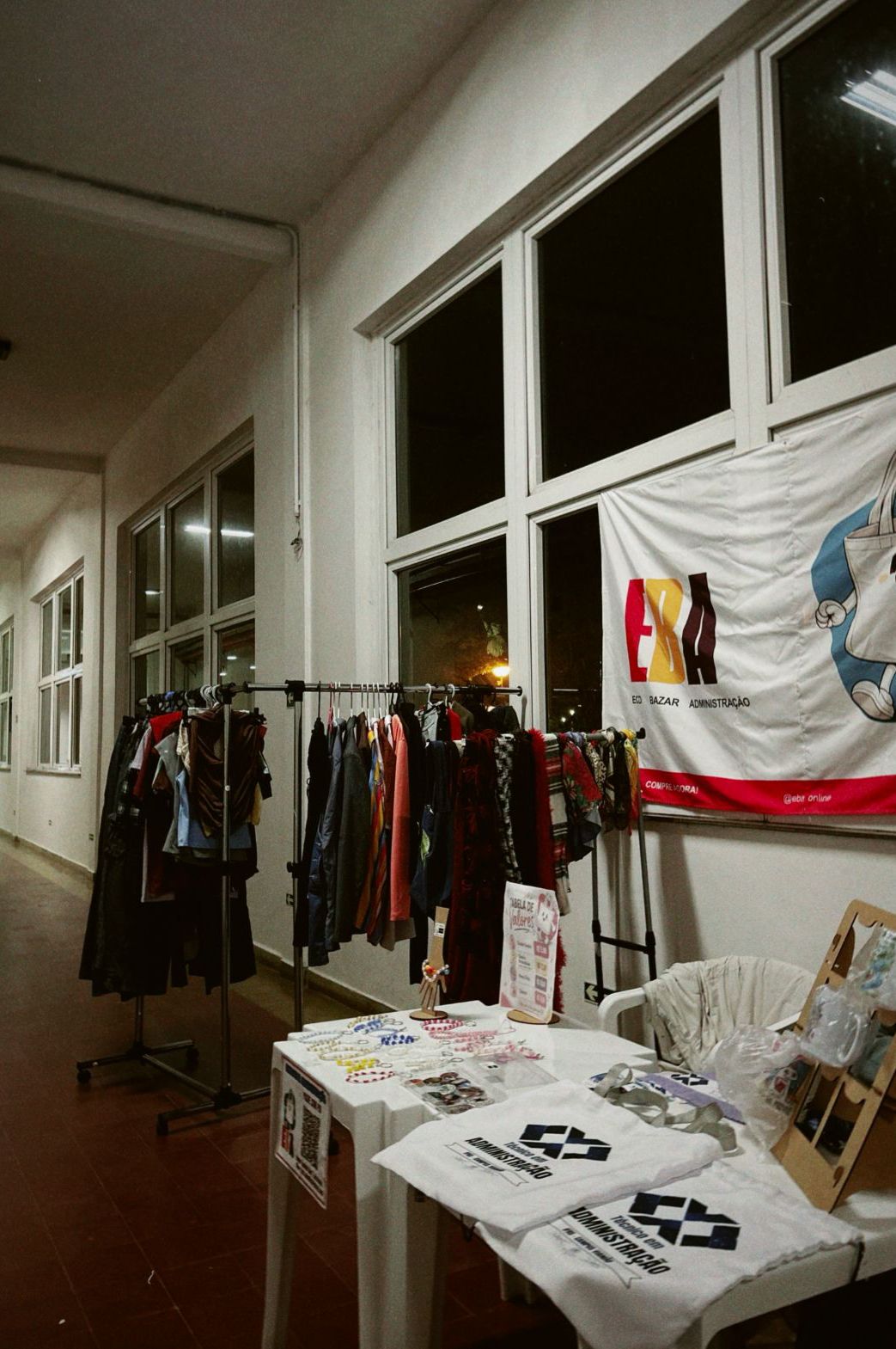 Banca da EBA na Multi-Feira, com araras de roupas e bandeira Eco Bazar Administra&ccedil;&atilde;o